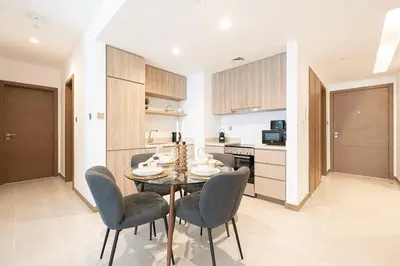 a kitchen and dining room with a table and chairs at FIRST CLASS 2BR Luxury Canal & Pool Views in Dubai