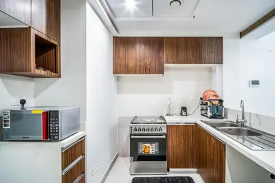 a kitchen with a stove and a microwave at Elegant 1BHK Metro Access & Trade Centre in Dubai