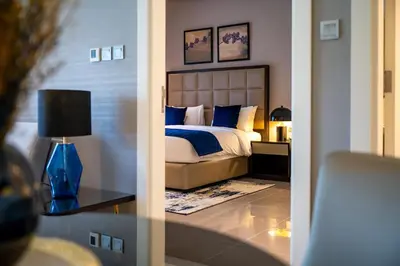 a bedroom with a bed and a table with a lamp at Burj Khalifa View - Cozy 1BR - Pool - Gym - Spa in Dubai