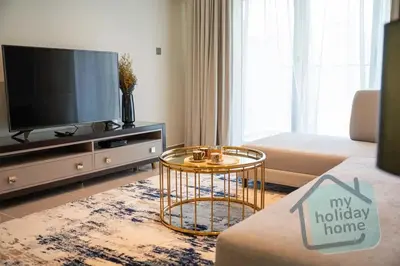 a living room with a tv and a couch at Burj Khalifa View - Cozy 1BR - Pool - Gym - Spa in Dubai