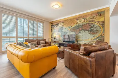 a living room with a large map on the wall at Walking Distance to Bluewaters Island, with The Walk JBR right at your Door and Private Beach Access, Al Bateen Residences, JBR by Deluxe Holiday Homes in Dubai
