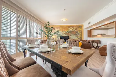 a dining room with a wooden table and chairs at Walking Distance to Bluewaters Island, with The Walk JBR right at your Door and Private Beach Access, Al Bateen Residences, JBR by Deluxe Holiday Homes in Dubai