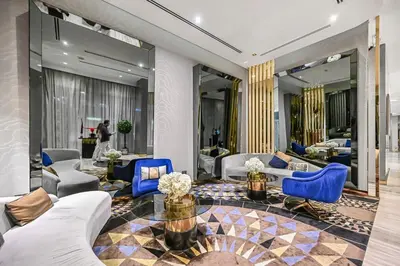 a living room with couches and blue chairs at Heart of Downtown - Dubai Mall & Burj next door in Dubai