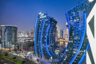 a large blue building in a city at night at Heart of Downtown - Dubai Mall & Burj next door in Dubai