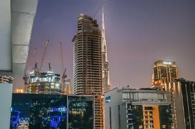 a group of tall buildings in a city at night at Live in the Center - Walk to Dubai Icons in Dubai
