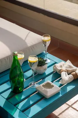 a blue table with two glasses of wine and a green bottle at Frank Porter - Rimal 1, JBR in Dubai
