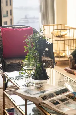 a glass coffee table with a wine glass and a plant at Frank Porter - Rimal 1, JBR in Dubai