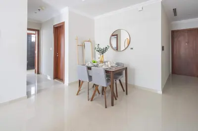 a dining room with a table and chairs and a mirror at Frank Porter - Dunya Tower, Downtown in Dubai
