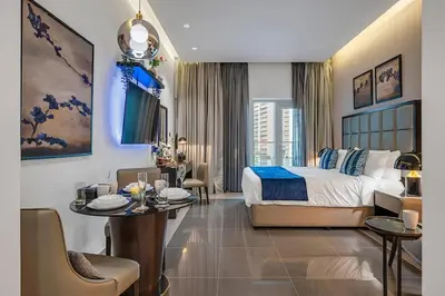 a bedroom with a bed and a table and chairs at DAMAC Majestine Studio with Pool, Spa and Gym Near Bus & DubaiMall in Dubai