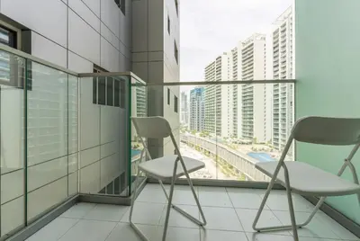 two chairs on a balcony with a view of a city at DAMAC Majestine Studio with Pool, Spa and Gym Near Bus & DubaiMall in Dubai