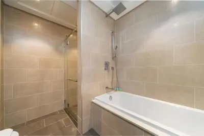 a bathroom with a shower and a bath tub at Modern and Elegant 1 Bed Retreat in Prime Location in Dubai