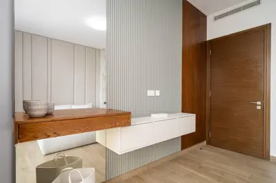 a bathroom with a wooden shelf and a wooden door at Modern and Elegant 1 Bed Retreat in Prime Location in Dubai