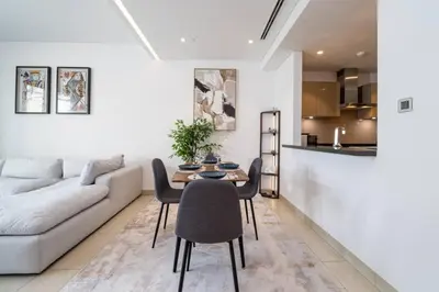 a living room with a couch and a table and chairs at Modern and Elegant 1 Bed Retreat in Prime Location in Dubai