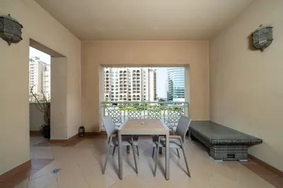 a dining room with a table and chairs and a window at Elegant Palm Living Upgraded Golden Mile 1 Bed in Dubai