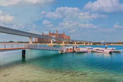 a bridge over a river with boats in the water at Elegant Palm Living Upgraded Golden Mile 1 Bed in Dubai