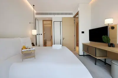 a bedroom with a large white bed and a television at Scenic 1BR - The Address JBR in Dubai