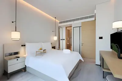 a bedroom with a large white bed and a desk at Scenic 1BR - The Address JBR in Dubai