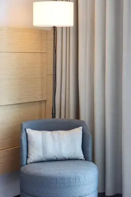 a pillow sitting on a chair next to a floor lamp at Scenic 1BR - The Address JBR in Dubai