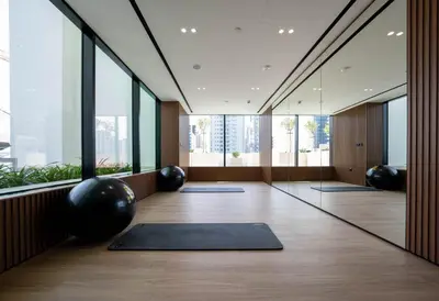 a yoga room with black mats and large windows at Soft Toned 1BR Retreat with Pool, Gym and Parking! in Dubai