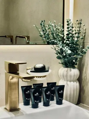 a group of cups sitting on a table with a vase at Soft Toned 1BR Retreat with Pool, Gym and Parking! in Dubai