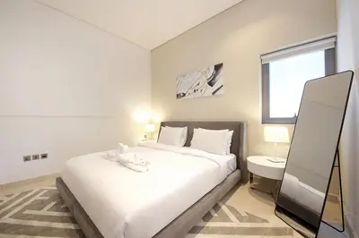 a bedroom with a large white bed and a window at The Sterling By OMNIYAT Near To Dubai Mall in Dubai