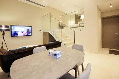 a living room with a table and a couch at The Sterling By OMNIYAT Near To Dubai Mall in Dubai