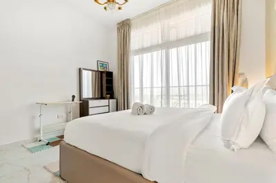 a bedroom with a large white bed with a window at FIRST CLASS 1BR Luxe Living in Jewelz in Dubai