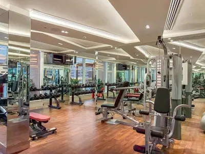 a gym with several treadmills and machines in a building at FIRST CLASS 1BR Luxe Living in Jewelz in Dubai