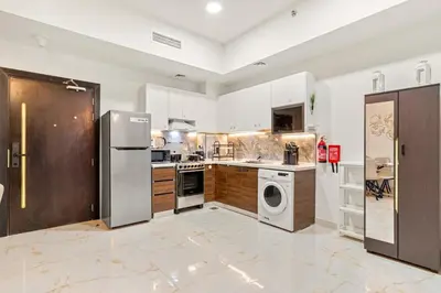 a large kitchen with stainless steel appliances and wooden cabinets at FIRST CLASS 1BR Luxe Living in Jewelz in Dubai