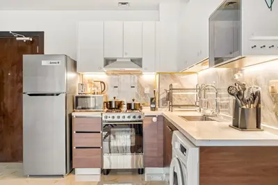 a kitchen with white cabinets and a stainless steel appliances at FIRST CLASS 1BR Luxe Living in Jewelz in Dubai