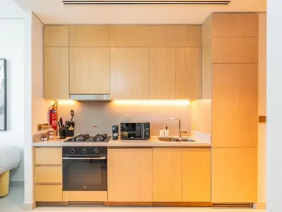 a kitchen with wooden cabinets and a stove and a sink at 1BR at Vida -Steps from Dubai Mall & Burj Khalifa in Dubai