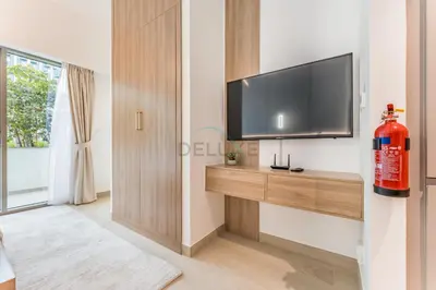 a living room with a flat screen tv on a wall at Modern Studio with Huge Balcony, Near Dubai Canal and Mins to Downtown Dubai, Fawad Azizi Residence, Al Jaddaf by Deluxe Holiday Homes in Dubai