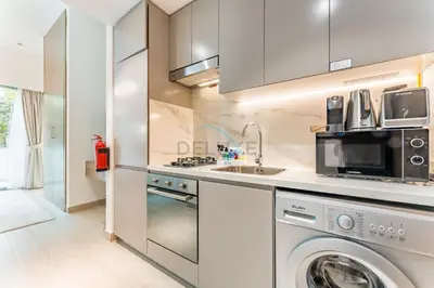 a kitchen with a washing machine and a sink at Modern Studio with Huge Balcony, Near Dubai Canal and Mins to Downtown Dubai, Fawad Azizi Residence, Al Jaddaf by Deluxe Holiday Homes in Dubai