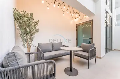 a living room with two chairs and a table at Modern Studio with Huge Balcony, Near Dubai Canal and Mins to Downtown Dubai, Fawad Azizi Residence, Al Jaddaf by Deluxe Holiday Homes in Dubai