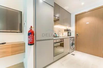 a kitchen with a fire extinguisher sitting on the wall at Modern Studio with Huge Balcony, Near Dubai Canal and Mins to Downtown Dubai, Fawad Azizi Residence, Al Jaddaf by Deluxe Holiday Homes in Dubai