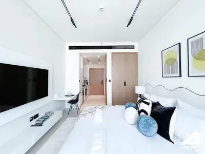 a white living room with a large screen tv at JVC Retreat with Pool & Balcony in Dubai