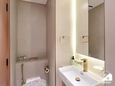 a white bathroom with a sink and a mirror at JVC Retreat with Pool & Balcony in Dubai