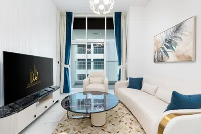 a living room with a white couch and a tv at Ahlan HH - Exclusive 2-BR Apartment in Opalz by Danube - Balcony with Mini Pool in Dubai