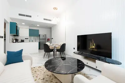 a living room with a tv and a table at Ahlan HH - Exclusive 2-BR Apartment in Opalz by Danube - Balcony with Mini Pool in Dubai