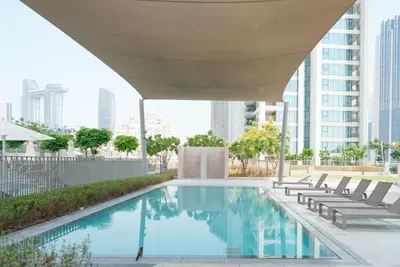 a swimming pool with chairs and a building at 54th Floor Burj Khalifa&Mall Access Infinity Pool in Dubai