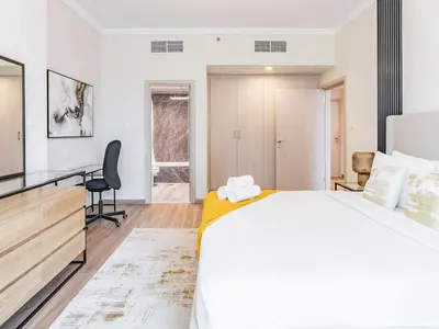 a bedroom with a large white bed and a desk at Spacious 1BR-Walk to Dubai Mall & Khalifa-Downtown Dubai in Dubai