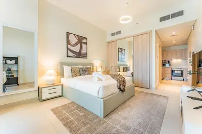 a bedroom with a large bed and a kitchen at Steps from Dubai Hills Park, Walk to Dubai Hills Mall, 15-Minute Drive to Burj Khalifa and Dubai Mall, Sway Residences, Dubai Hills by Deluxe Holiday Homes in Dubai