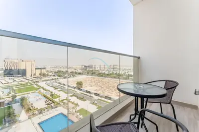 a balcony with a table and chairs and a view of the city at Steps from Dubai Hills Park, Walk to Dubai Hills Mall, 15-Minute Drive to Burj Khalifa and Dubai Mall, Sway Residences, Dubai Hills by Deluxe Holiday Homes in Dubai