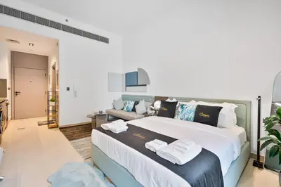 a bedroom with a large bed and a couch at Posh Studio in MBR by Deleguest in Dubai