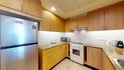 a kitchen with wooden cabinets and a stainless steel refrigerator at Al Mesk Tower - One Bed with Scenic Marina Views in Dubai