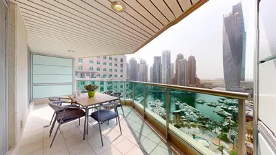 a balcony with a table and chairs and a view of a city at Al Mesk Tower - One Bed with Scenic Marina Views in Dubai
