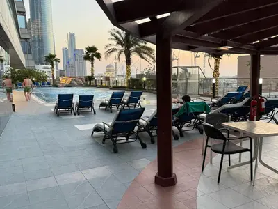 a patio with chairs and tables and a swimming pool at Luxury 2 BHK in Ocean Heights at Dubai Marina Living with Stunning Views in Dubai