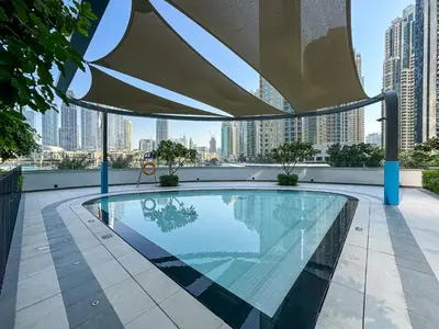 a swimming pool with an umbrella on top of a building at CitiHome Stylish 1BR Grande in Dubai