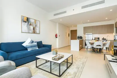 a living room with a blue couch and a table at CitiHome Stylish 1BR Grande in Dubai