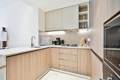 a kitchen with wooden cabinets and a sink at 2BR Homely Apartment in Arjan in Dubai